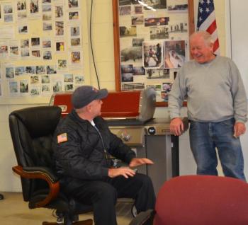 Freeport Fire Chief (and former Rockland Fire Chief) Charlie Jordan takes a seat in Bruce Woodward’s new executive chair. (Photo by Lynda Clancy)