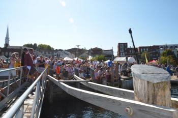 A crowd lined the dock to watch the annual crate race in Camden Harbor at the Windjammer Festival. (Photo by Lynda Clancy)