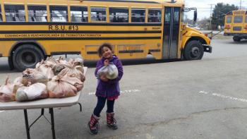 Kindergartener Kamea Thomas helps to hand-out Grab'n'Go produce bags during dismissal at South School in April. (Photo courtesy Brenda Thomas)