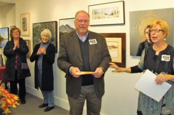 A slightly embarrassed Mark Coates accepts his award from Sarah Wilde of the Boothbay Region Art Foundation (BRAF) board of directors on Oct. 13. LISA KRISTOFF/Boothbay Register