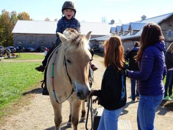 A young rider is delighted to begin his ride on this beautiful pony at SeaHorse Stables’ open farm day Oct. 14. (photo by Erica Thoms)