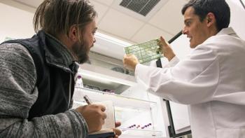 Scientist Joaquίn Martίnez Martίnez, right, shows artist Justin Levesque vials of marine algae infected with viruses at Bigelow Laboratory for Ocean Sciences in East Boothbay. As a visiting artist-in-residence at the nonprofit research laboratory, Levesque recently began working to gain inspiration for an art exhibit that is planned for public display in summer 2019. Courtesy of Bigelow Laboratory