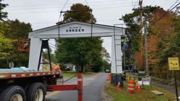 The iconic Camden-Rockport arch, removed Aug. 23 after a delivery truck crashed into the left pillar, was lowered back in place Oct. 4 by Rockport Steel. (Photo by Sarah Shepherd)