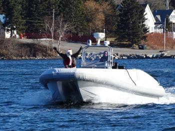 Santa waves to the crowd as he makes his way to the docks. (photo by Erica Thoms)