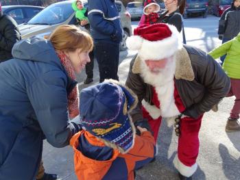 Santa greets an eager child as he arrives at Belfast’s Boathouse. (photo by Erica Thoms)