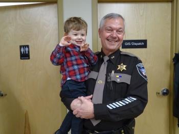 Trafton holds grandson Lincoln before the ceremony gets underway. (photo by Erica Thoms)