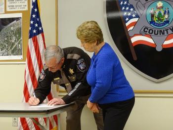 Trafton signs the oath he just took. (photo by Erica Thoms)