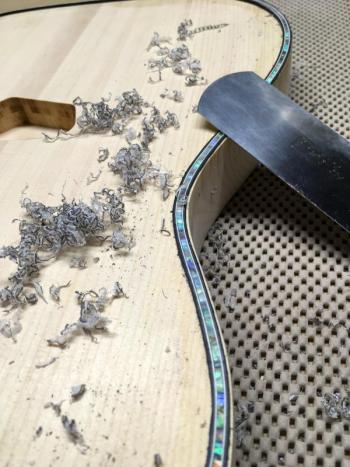 The purfling of a Northwoods guitar is scraped during the guitar making process. (Courtesy Thad Chilton)