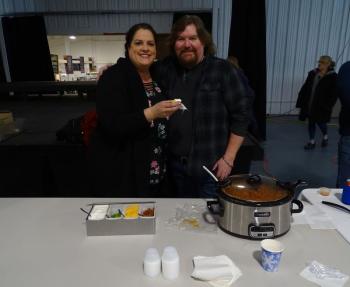 Emily Berry (left) and Bob Waldron (right) said their chili is made with two kinds of pork, including bacon, as well as chicken, steak, and nine varieties of peppers. “We’re hoping to unseat the champs,” Waldron said, gesturing toward cook-off neighbor Jarod Colson. Waldron said the two became friends during last year’s competition. (photo by Erica Thoms)