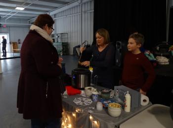 Jill Artkop serves some of her chili to a taste-tester. (photo by Erica Thoms)