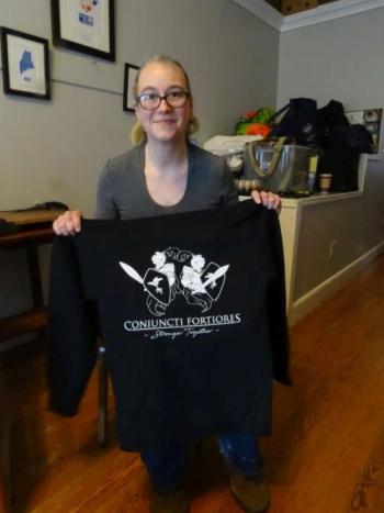 Allison Harrell stands with a Game Loft sweatshirt, designed by the youth board. (photo by Erica Thoms)