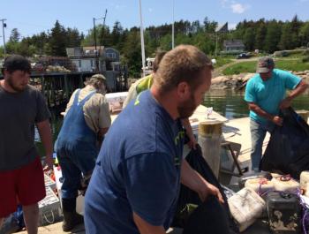 Left to right: Lobsterman Seth Young, electrician Paul Murray, lobsterman Josh Ames, and lobsterman Clayton Philbrook of Matinicus help to load the “Sea Wife.” (Photo courtesy Eva Murray)