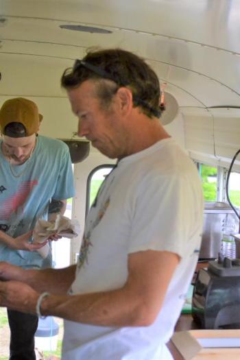 Rockport Harbor Food Bus owner Bobby Morgan, front, in the process of ensuring all prep work is completed prior to opening. (Photo by George Harvey)