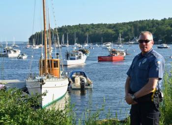 Rockport Police Officer Travis Ford is on duty at the launching for one of the town’s more festive occasions. (Photo by Lynda Clancy)