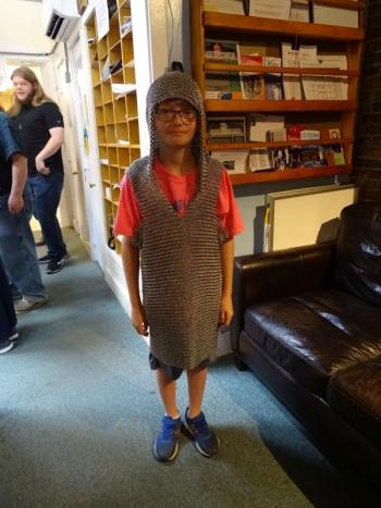 A young participant poses in chainmail armor created for and donated to the Loft. (photo by Erica Thoms)