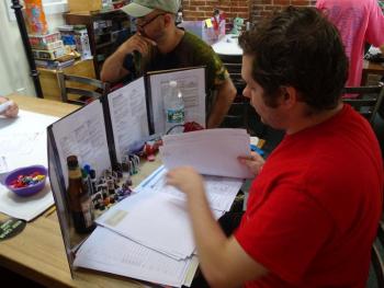 One of the game’s Dungeon Masters looks over game material as participants ready for the second session. (photo by Erica Thoms)