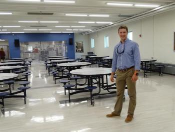 VP Colden Golann stands in the updated cafeteria, with the updated kitchen visible in the background. (photo by Erica Thoms)