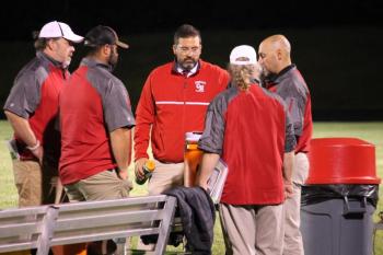 Camden Hills head football coach Jeremy Marks (facing) talks with his assistant coaches at a Sept. 6 game against Old Town. (Courtesy Sally Russillo)