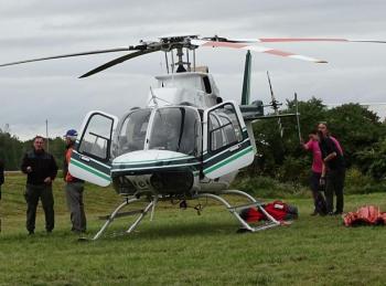 Maine Forest Service’s Chief Pilot John Crowley (far left) stands next to one of the Service’s helicopters. (photo by Erica Thoms)