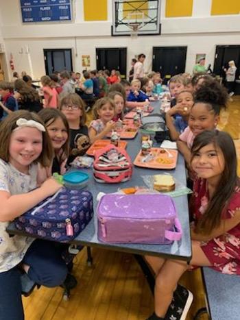 Third graders are all smiles at lunchtime.