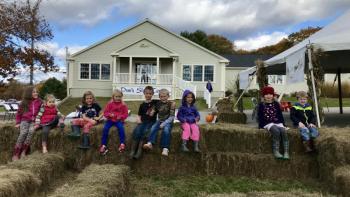 Children perch on hay bales during the October 26 Harvest Fest. (Photo courtesy Dow Furniture)