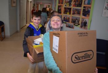 Maddox Lowell and Addison Lincoln help load the food donations. (Photo courtesy Thomaston Grammar School)