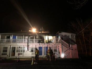 Firefighters drill holes through the roof as they search for hotspots following knockdown of the initial blaze. (Photo by Lynda Clancy)