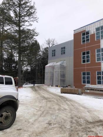 This is a view of the south side of the academic wing. The Nishiha siding in red is being installed in several bump out areas. (Photo courtesy Steve Claffie)