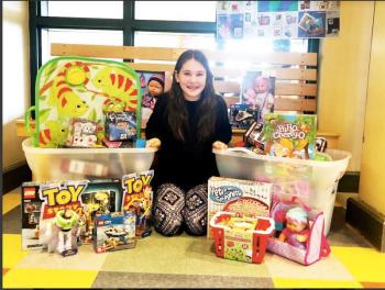 Summer Staples, a fifth grader at Warren Community School, sits with all of the gifts her community donated for children at the Barbara Bush Children’s Hospital. Photo courtesy Jessica Berry.