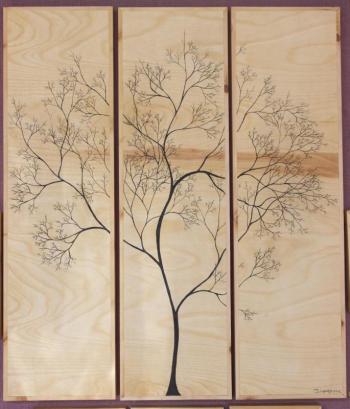 Her trees painted upon scraps of wood Puckett saves from his boat building projects. Felicia Cinquegrana