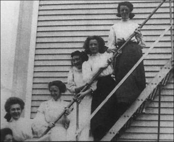 Five seniors pose on the fire escape at Camden High School in 1909, the year of their graduation. From left are Mary Pendleton, Stella Derry, Marion Payson, Margaret Cripps, Edna St. Vincent Millay, and Corinne Sawyer. (Collections of Camden Public Library)