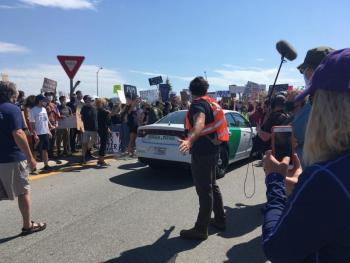 The first car in the border patrol caravan being forced to backup, yielding to the protestors. (Photo courtesy Molly Mulhern)