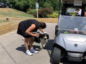A golfer takes a moment before the start of the tournament to visit with one of the canine MVP’s present. (Courtesy PAWS)