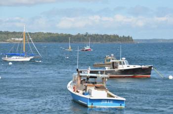The ‘Kristin Marie’ helps to upright the catamaran and tow it, and its sailor, back to the harbor. (Photo by Lynda Clancy)