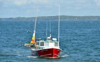 Nick Heal, captain of the Kristin Marie, along with crew members Alex Bryant and Jared Gilbert tow the disabled catamaran and sailor Brendan Browne back to the Lincolnville Harbor dock, beside the ferry landing at Lincolnville Beach. (Photo by Lynda Clancy)
