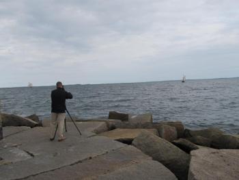 A reporter for WABI tries to get both oncoming vessels into frame as they sail toward the Rockland Breakwater. (Photo by Kay Stephens)