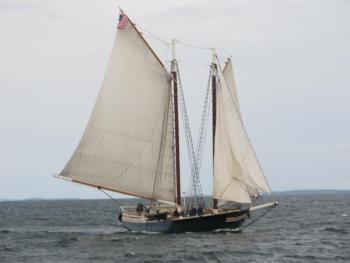 Stephen Taber under full sail seconds away from crossing the finish line of the Rockland Breakwater. (Photo by Kay Stephens)