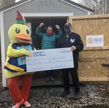 Lucky the Duck and West Bay Rotarian Ray Fink present a check to One Less Worry’s Executive Director Sharon Hobson (in front of the shed that was donated to OLW by West Bay Rotary). (Photo courtesy West Bay Rotary)