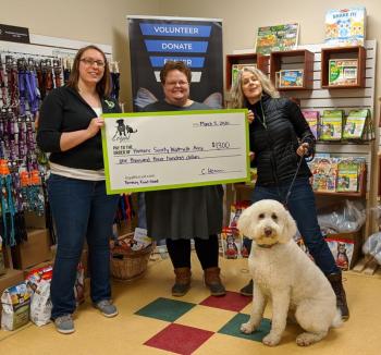 L to R: Chelsie Herrin (marketing manager for the Loyal Biscuit) presents a Fenway Fund grant check to Lisa Oakes (Humane Society Waterville Area executive director) and Dianna Demers (HSWA Board of Directors secretary) with her rescue dog, Sadie the Doodle. (Photo courtesy Loyal Biscuit)
