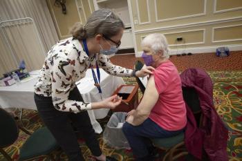 Cheryl Liechty, MD, MPH, administers the first of two doses of the Pfizer vaccine to Rockport resident Marjorie Hill, 91, at the MaineHealth COVID-19 vaccine clinic held at the Samoset Resort on Jan. 30, 2021. Dr. Liechty, an infectious disease specialist who sees patients at Pen Bay Medical Center (PBMC), leads the COVID-19 response at both PBMC and Waldo County General Hospital. (Photo courtesy MaineHealth)