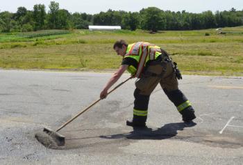 Camden Firefighter Jack Orestis cleans up the crash debris.