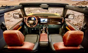 A topless Bronco, roll cage on display, with the 7-speed manual transmission. Note that the wing mirrors are mounted on the fenders, so they remain when the doors are removed (unlike a Jeep Wrangler). The leather interior is not necessary for a good time.