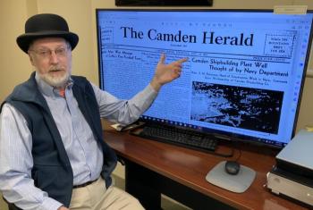Ken Gross, assistant director of the Camden Public Library, in front of the newly digitized Camden Herald Archives. (Photo courtesy Camden Public Library)