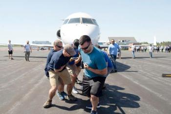 Auburn police officers Travis Barnies, right, and Derek Drouin, second from left, anchor the Auburn Policy Department team at last year’s Big Brothers Big Sisters of Mid-Maine Plane Pull to support local youth mentoring. (Photo by Daryn Slover/Sun Journal)
