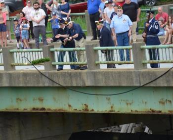 Tossing the wreath into the Goose River, where it flows into Rockport Harbor.