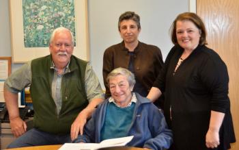 Honoring Sani Fogel at the Rockport Town Office May 31: Rockport Select Board member Mark Kelley, Sani Fogel (seated), her daughter Marya Flanagan, and Select Board Chair Michelle Hannan. (Photo by Lynda Clancy)