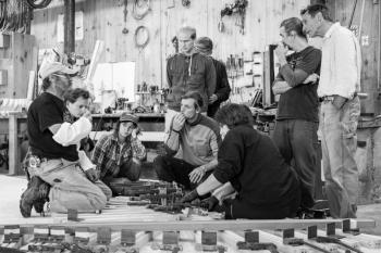 Apprentices, instructors and volunteer, John England, discussing how to laminate frames for a 38’ racing sloop. (Photo by Erin Tokarz)