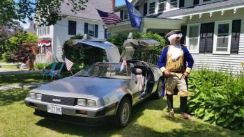A local resident, or “George Washington” poses next to a DMC car, just like the DeLorean time machine in the movie Back to the Future. (Photo by Sarah Shepherd)