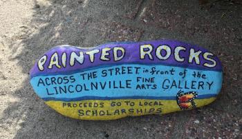 You’ll find Marge Olson’s painted rocks for sale in front of Dwight Wass’ gallery, and see Marge herself sitting at a table cluttered with paints and rocks-in-progress in her open barn door on Beach Road. If she’s not painting a rock she’s working in her several flower gardens, or maybe walking her deaf white boxer along the road. She communicates with her via signs!
photo by Diane O’Brien rock