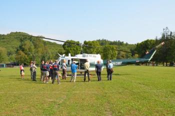 Members of the Camden Fire Dept. gather around one of the five Vietnam era UH-1H (Huey) utility helicopters owned by the Maine Forest Service and which are used for fire fighting and search and rescue. (Photo by Lynda Clancy)